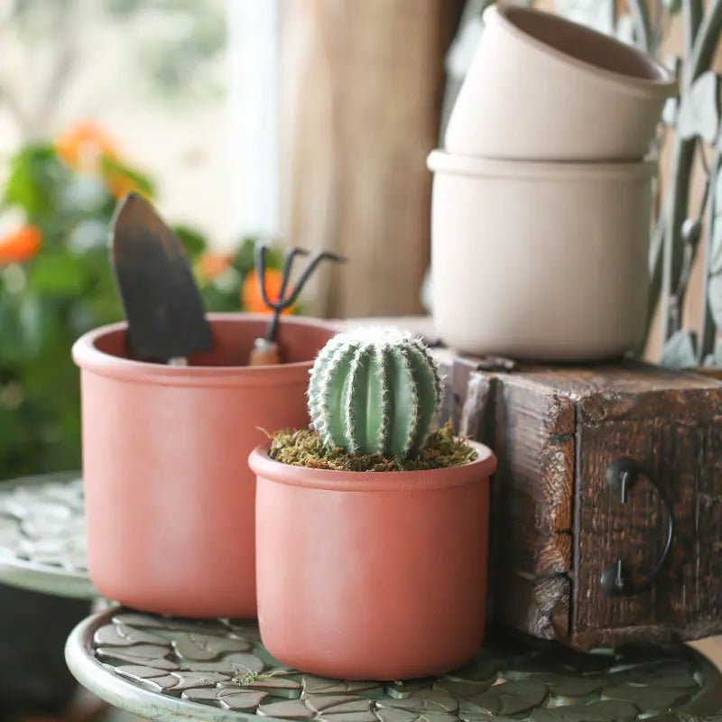 Decorative Succulent Planter with Iron Stand showcasing a medium-sized white pot hanging from a black iron frame.